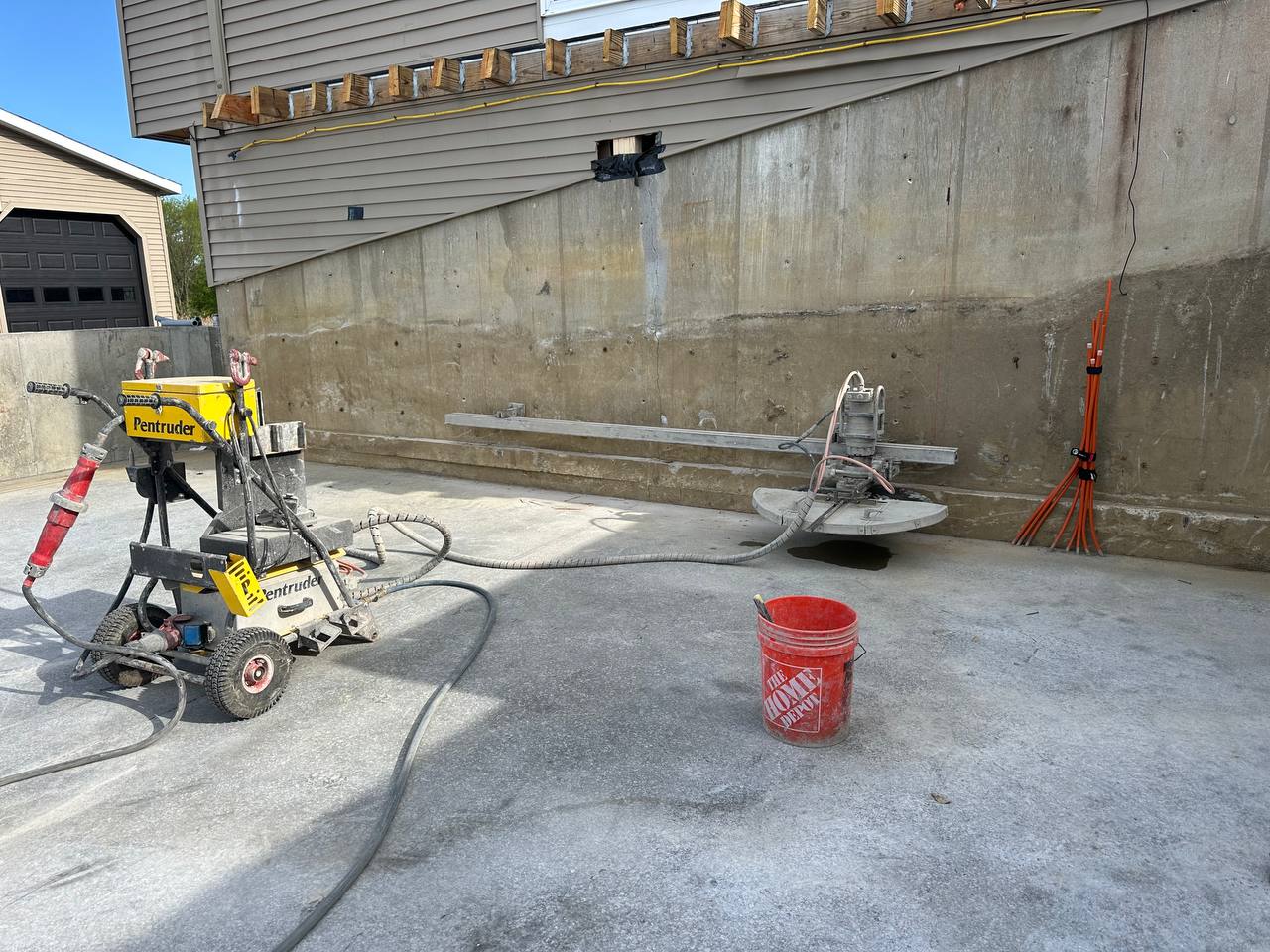 Pentruder track-mounted wall saw on concrete foundation wall for door opening cutting