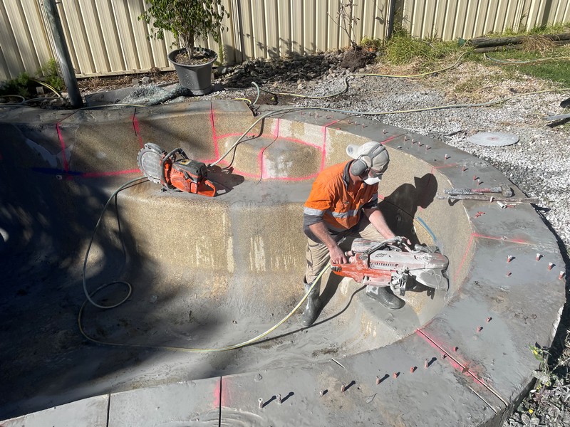 Concrete cutting and demolition worker using hand saw for controlled section removal